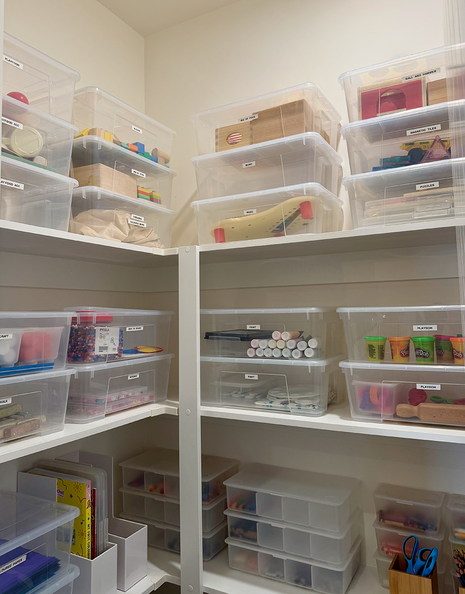Children's cupboard organised with labelled storage containers